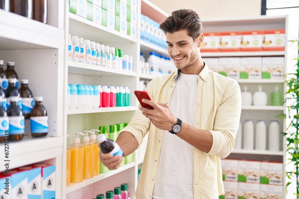 Young hispanic man customer make photo by smartphone to medicine bottle at pharmacy Young hispanic man customer make photo by smartphone to medicine bottle at pharmacy