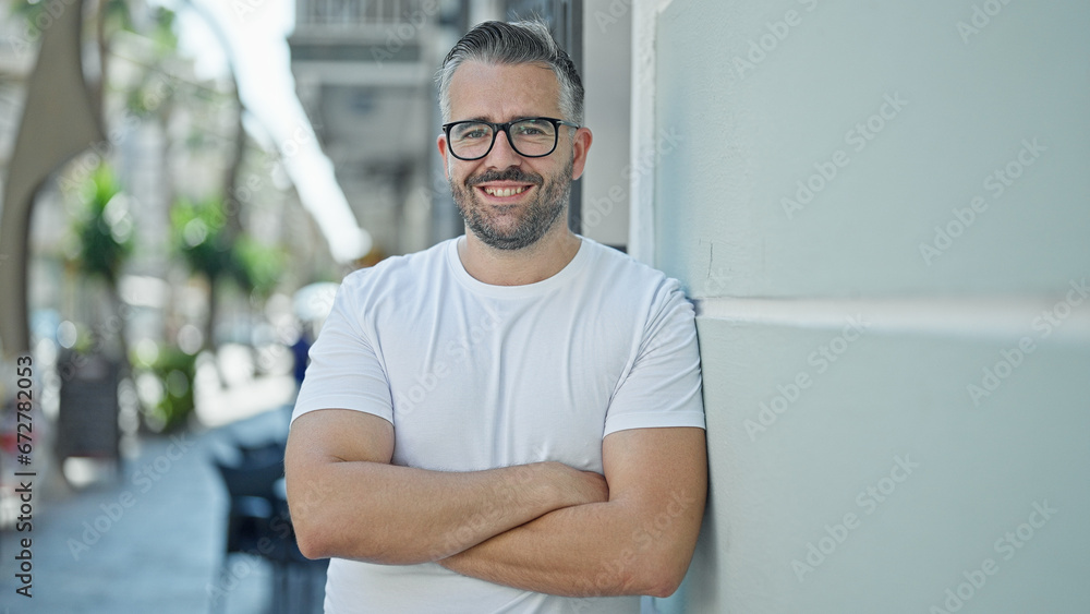 Grey-haired man smiling confident standing with arms crossed gesture at street Grey-haired man smiling confident standing with arms crossed gesture at street