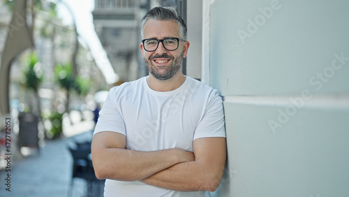 Grey-haired man smiling confident standing with arms crossed gesture at street