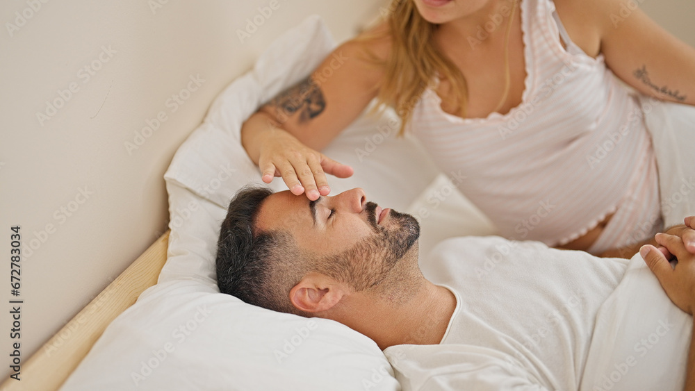 Man and woman couple lying on bed touching head while sleeping at new home Man and woman couple lying on bed touching head while sleeping at new home
