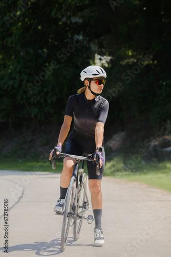 Concept woman riding bike.Cyclist Woman riding bike in helmets go in sport outdoor .Health care. © Jittapisut