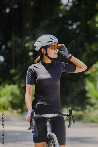 Concept woman riding bike.Cyclist Woman riding bike in helmets go in sport outdoor .Health care.