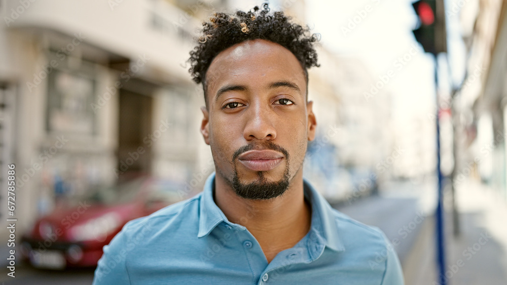 African american man standing with serious expression at street African american man standing with serious expression at street