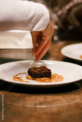 Garnishing a brownie with almond slivers, perfect for image stock and recipe sites.