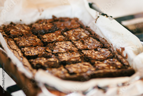 Freshly baked brownies cut into squares on parchment paper, ideal for dessert blogs.