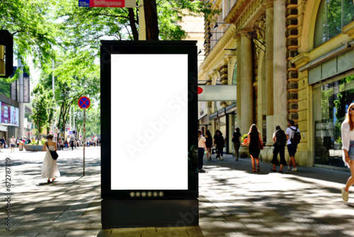 billboard on busy street. blank white poster and advertiser ad space. digital outdoor display lightbox. base for mockup. empty display panel. glass design. soft streetscape. shopping street background