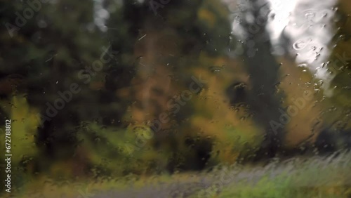 vue au travers du pare brise d'une voiture le paysage sous la pluie
