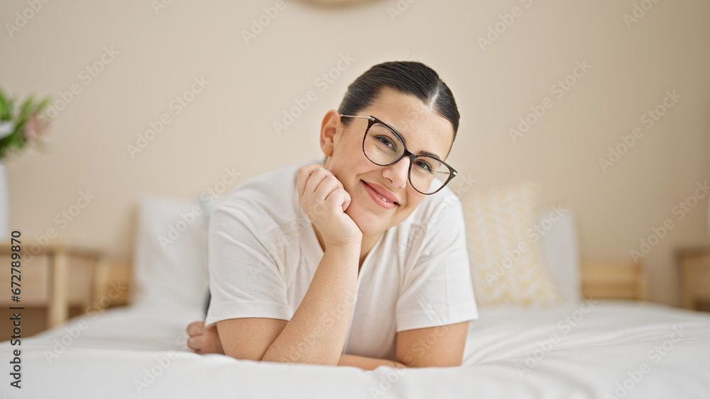 Young beautiful hispanic woman lying on bed smiling at bedroom Young beautiful hispanic woman lying on bed smiling at bedroom