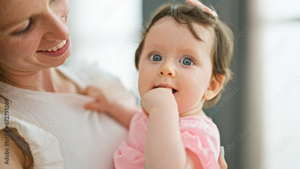 Mother and daughter hugging each other smiling at home