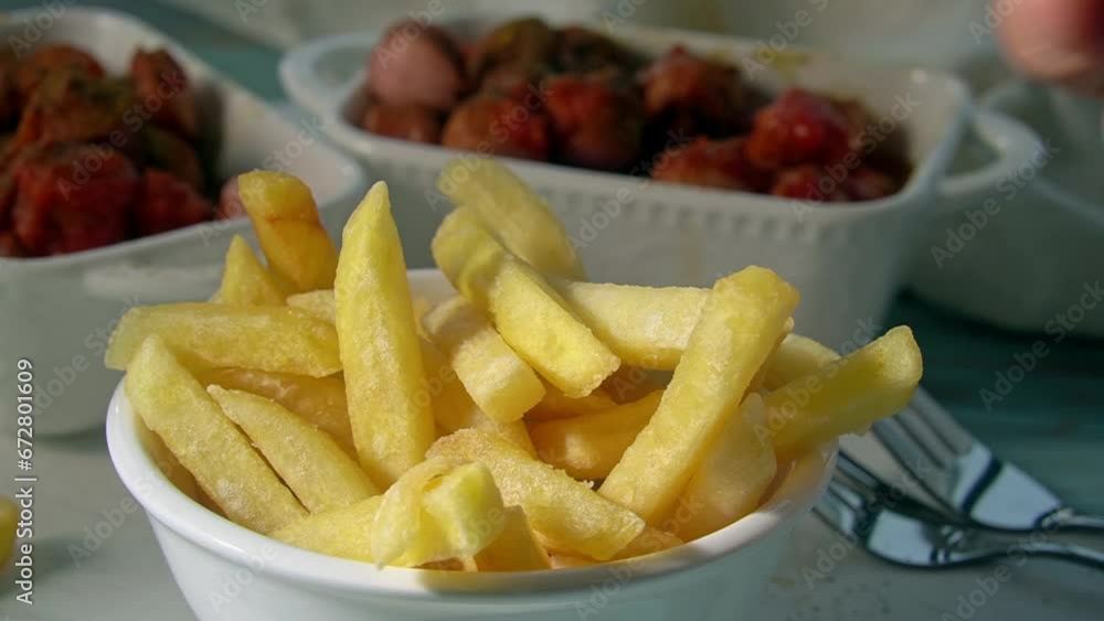 Eating french fries, hand taking a fried potato stick Eating french fries, hand taking a fried potato stick