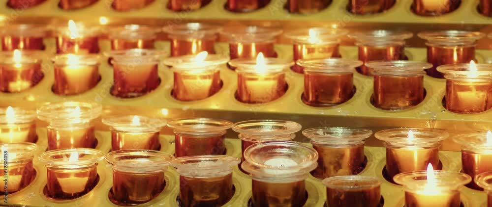 Burning wax candles background. Female hand holding lit candle. Prayer ritual in church. Burning wax candles background. Female hand holding lit candle. Prayer ritual in church.