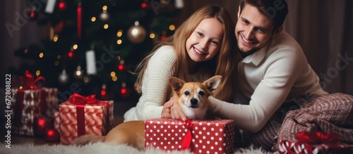 Happy father with daughter and dog celebrating christmas and new year. Home holiday and Christmas tree © ETAJOE