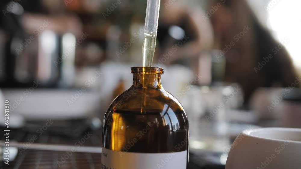 pipetting candle making oil, scented in a brown jar pipetting candle making oil, scented in a brown jar