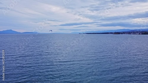 Drone footage of kite surfing on Lac Leman, sports in lake geneva, aerial large shot over the water