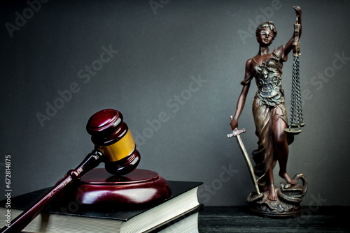 Themis, judge's gavel and books on jurisprudence on a wooden background. Legal and law concept.