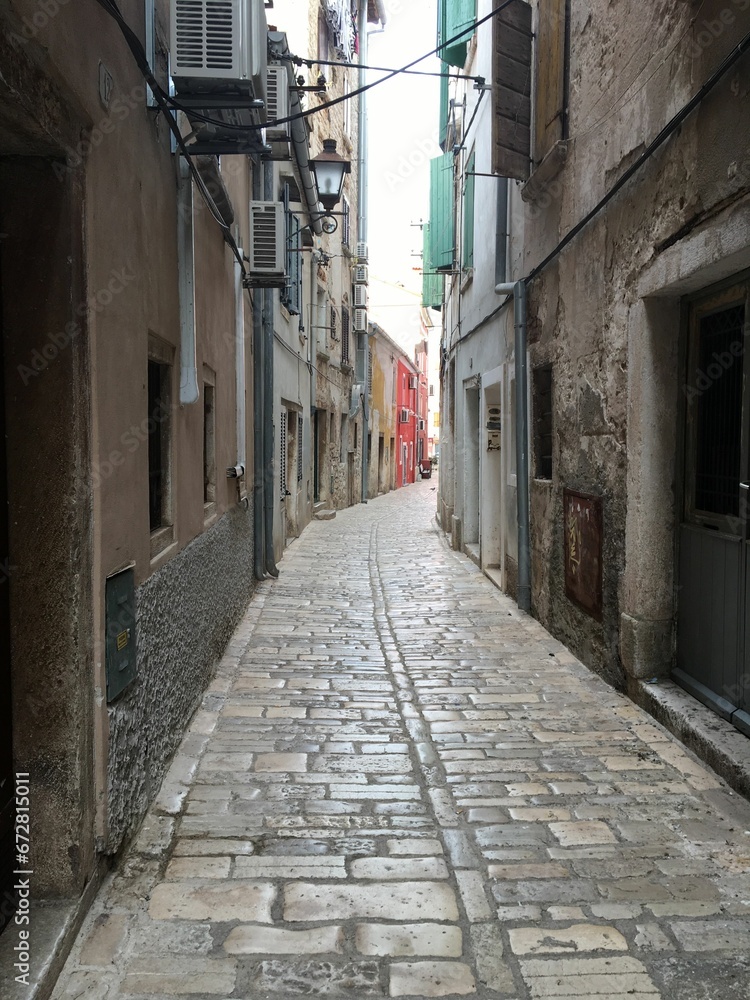 Picturesque alleyway between two buildings in a town or city, leading into the unknown