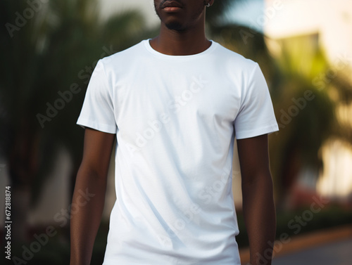 A young black male (African American) model wearing a white t-shirt, no face, mockup, in an outdoor setting