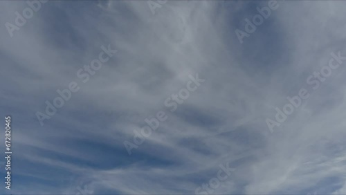 Natural blue and white sky background with moving Cirrus and condensation clouds - timelapse. Topics: weather, meteorology, climate, atmosphere photo