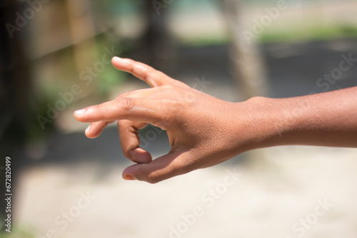 A man is pointing three fingers on his hand in front and blurred background © Rokonuzzamnan