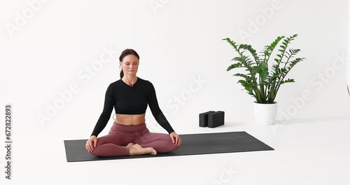 A woman performs the Kapalabhati exercise for the respiratory tract, cleanses the lungs and paranasal sinuses, inhales and exhales through the nose, and trains while sitting in the lotus position photo