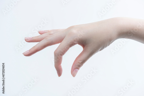 指先で摘む女性の手（下向き）