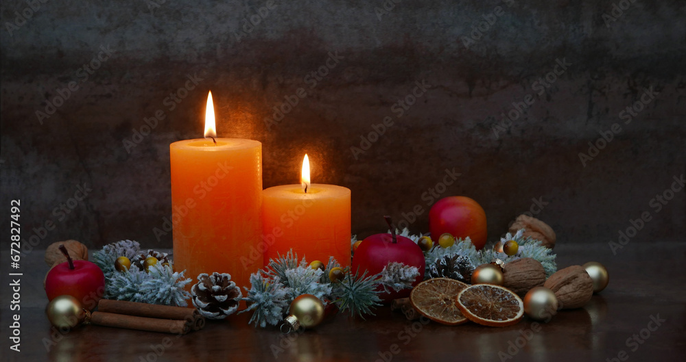 Fototapeta premium Romantic Christmas decoration with burning candles, fir branches, cinnamon sticks and orange slices with space for text.