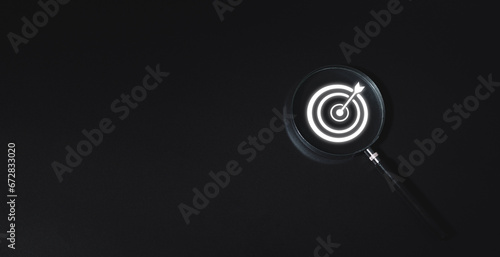 Business concept, business strategy, magnifying glass and target icon, black background photo