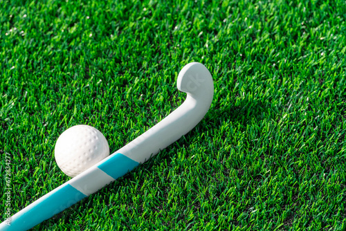 Field hockey stick and ball on green grass. Team sport concept. Horizontal sport theme poster, greeting cards, headers, website and app