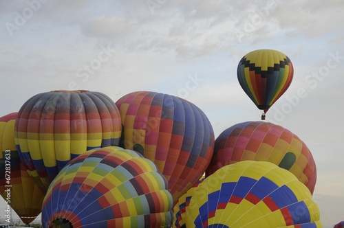 Colorful array of hot air balloons soaring through the sky at a festive balloon festival