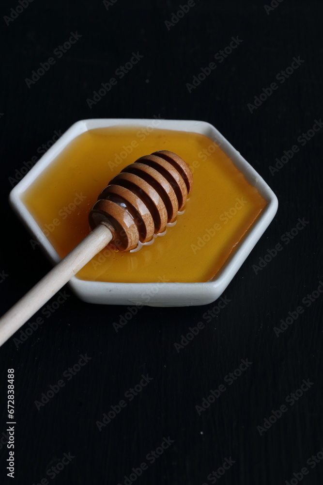 Fresh Honey with wooden honey spoon on a black background Fresh Honey with wooden honey spoon on a black background