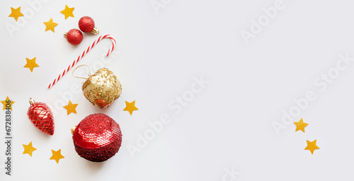 Christmas or New Year's flat lay composition of various decorative elements, sparkles,stars and Christmas toys in red and golden,green tones isolated on a white background. top view. copy space