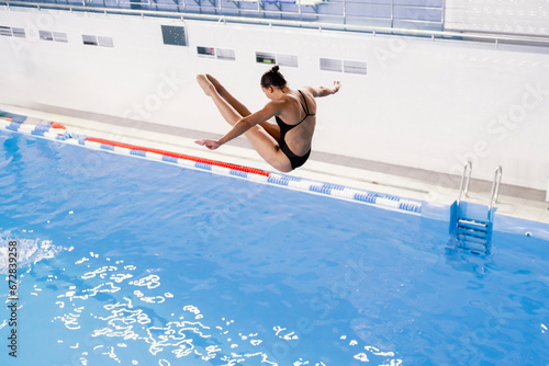 sports diving, an athlete doing a somersault, jumping from a springboard into the pool