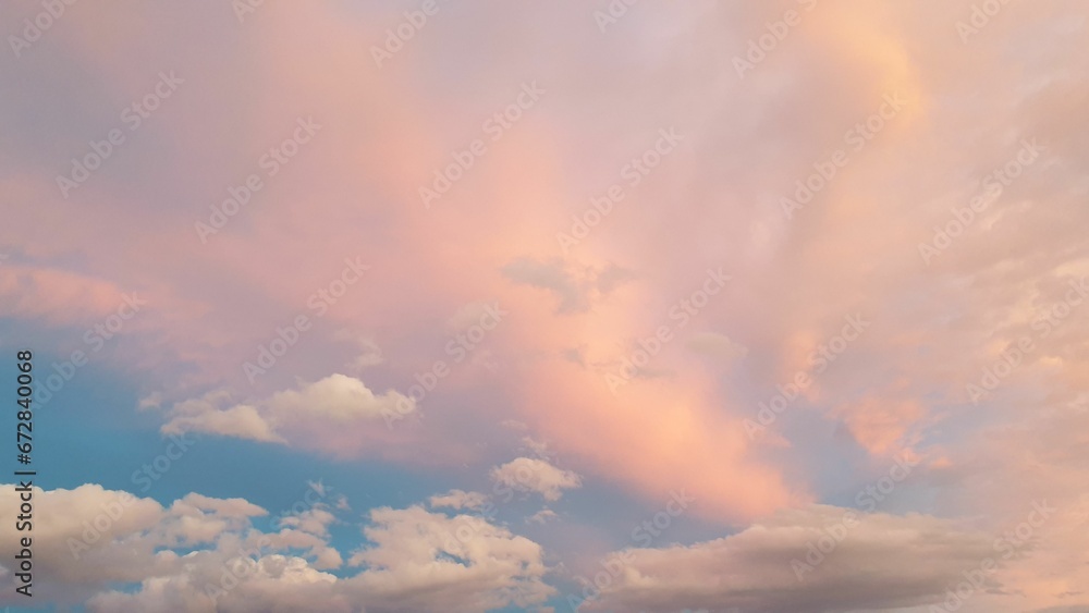 Sky filled with white, fluffy clouds at a soft pink sunset Sky filled with white, fluffy clouds at a soft pink sunset