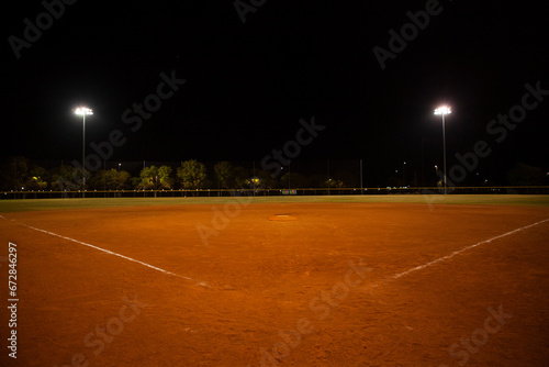 Empty baseball field at night, view from home plate photo