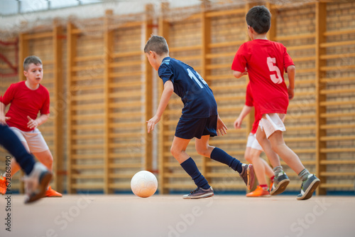  Kids playing football soccer game on sports field.