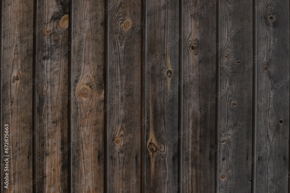 Naklejka premium Close up photo shot rustic aged brown wood texture gradient front view. Wooden planks for natural background with vertical lines. Log cabin material - interior exterior design in traditional houses.