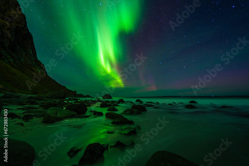 Awesome Northern lights over the beach, reflection in the silky water. Lofoten islands, Norway. © mario