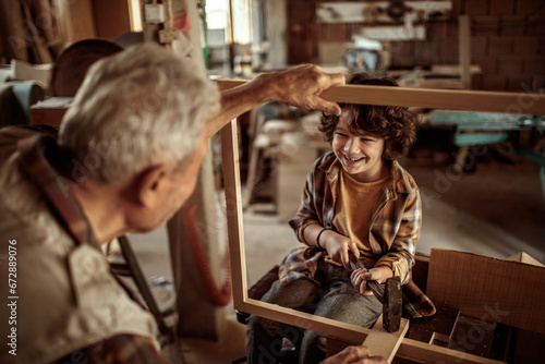 Little boy learning in grandfather carpenter shop © Geber86