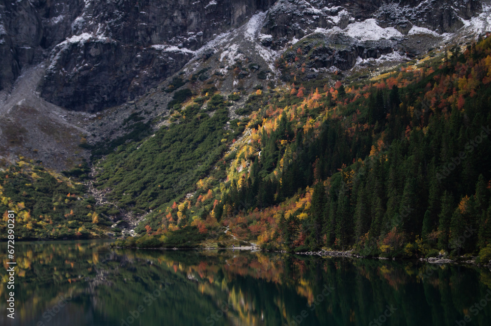 Serene landscape capturing the fall colors at Morskie Oko. Mountainous background, pristine lake reflecting vibrant autumn foliage, perfect for nature enthusiasts and travel articles