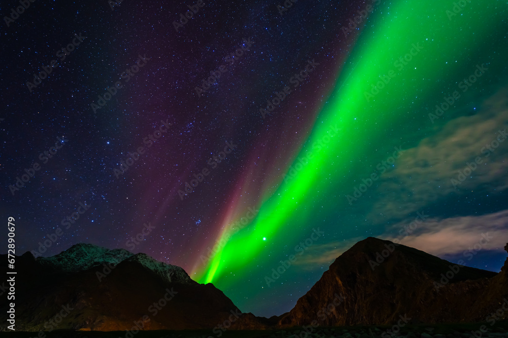 Awesome Northern lights over the snowy mountains. Lofoten islands, Norway.