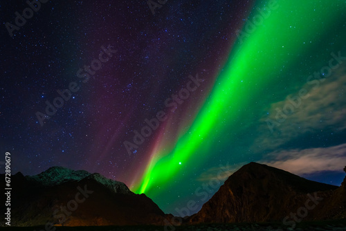 Awesome Northern lights over the snowy mountains. Lofoten islands, Norway.