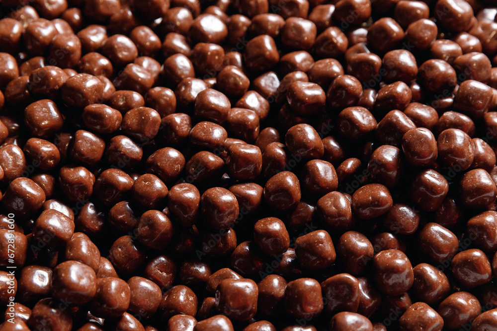 Closeup brown dragee, chocolate covered nuts, sweet candy background Closeup brown dragee, chocolate covered nuts, sweet candy background