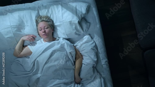 Sleeping man talking in his sleep in bed, top view. Woman suffering from parasomnia sleep disorders.