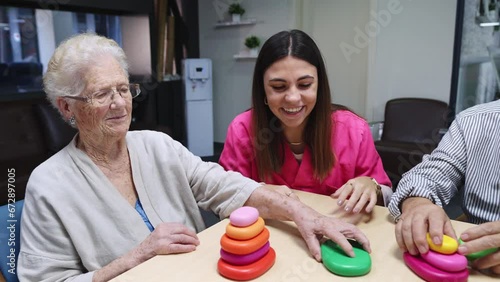 Happy nurse and old people interacting in a nursing home photo