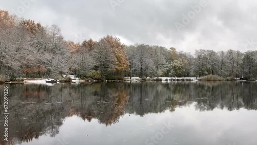 trees covered with snow and frost, as if silver, are reflected in the smooth mirror water of the river, winter landscape, panorama photo