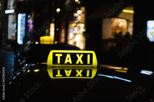 Taxi sign on the roof of a taxi at night