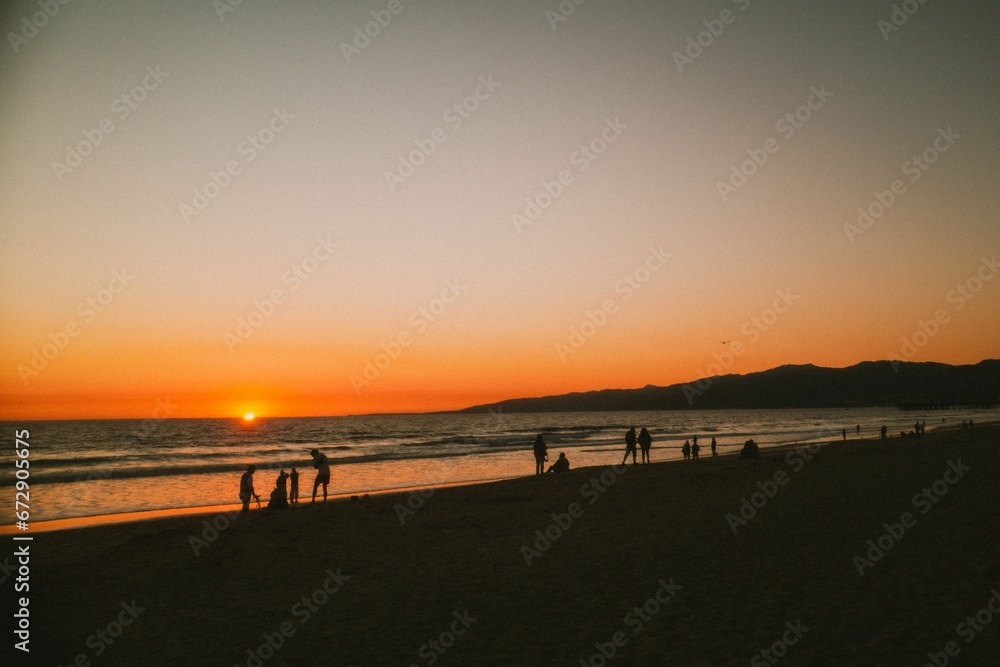 Group of people on the beach at sunset
