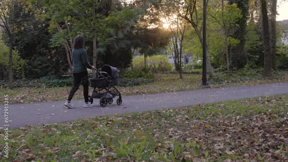 Caucasian mother walking with stroller in park. Burnaby, Vancouver, BC Canada. Slow Motion. High quality 4k footage Caucasian mother walking with stroller in park. Burnaby, Vancouver, BC Canada. Slow Motion. High quality 4k footage