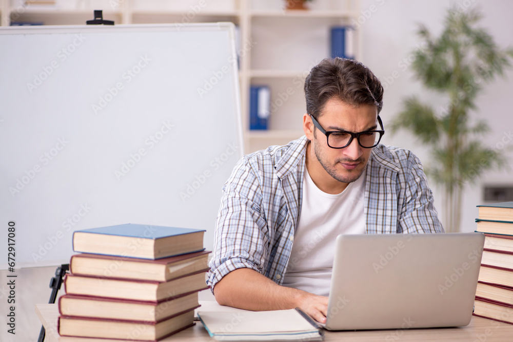 Young male student preparing for exams in the classroom Young male student preparing for exams in the classroom