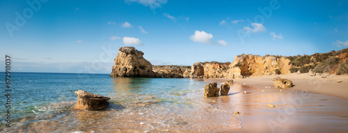 Golden beaches and sandstone cliffs near Albufeira, Portugal Panoramic banner image.